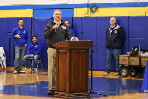 A coach speaking at the podium during the East Meadow High School varsity awards ceremony