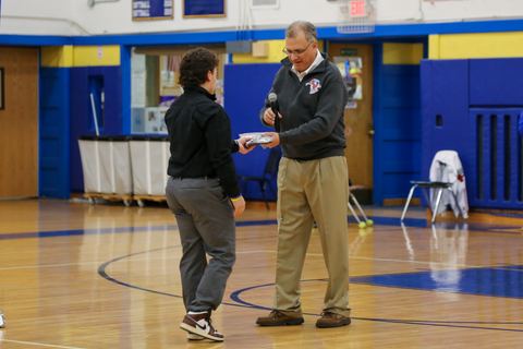 A player walking up to receive his award from a coach