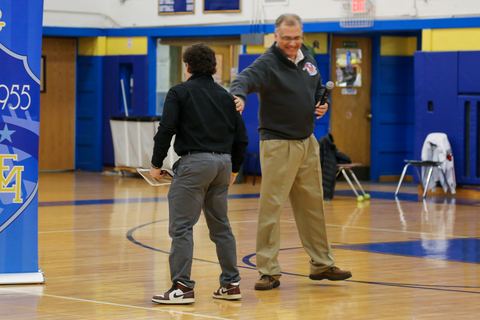 A coach congratulating a player after the presentation