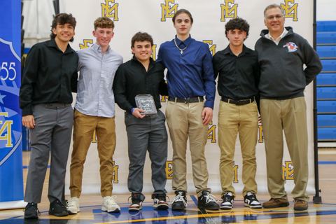 Five players standing with a coach, holding their awards