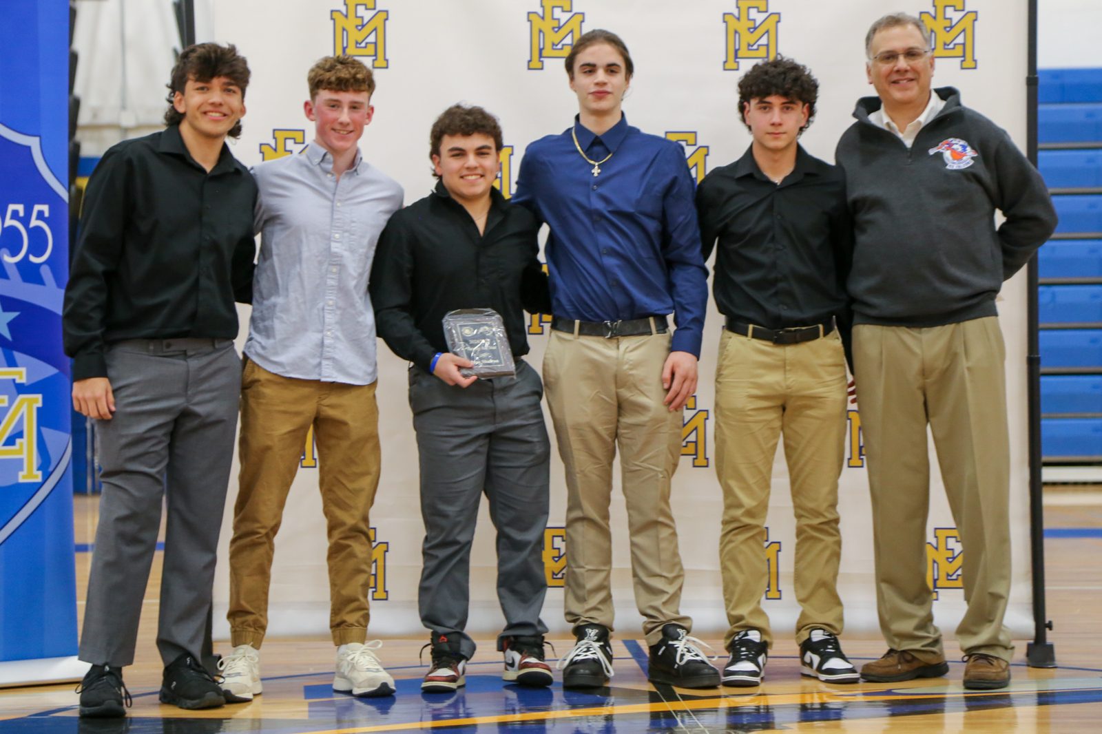 Five players and a coach at the East Meadow High School varsity awards night