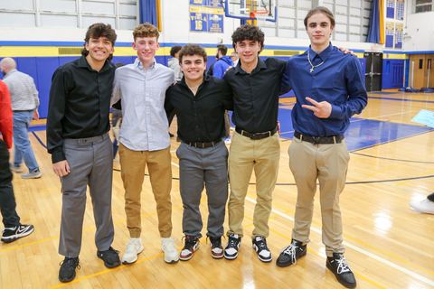 Five players standing shoulder to shoulder with their awards