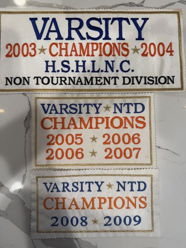 Championship banner listing H.S.H.L.N.C. Varsity titles for 2003-2004 and Non-Tournament Division titles for 2005-2006, 2006-2007 and 2008-2009