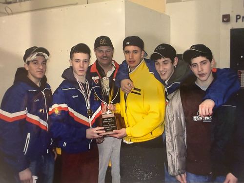 Five players and a coach holding a plaque and a trophy at an awards presentation