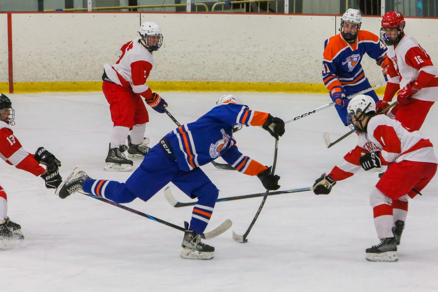 A Falcons forward driving through traffic against a team in red and white